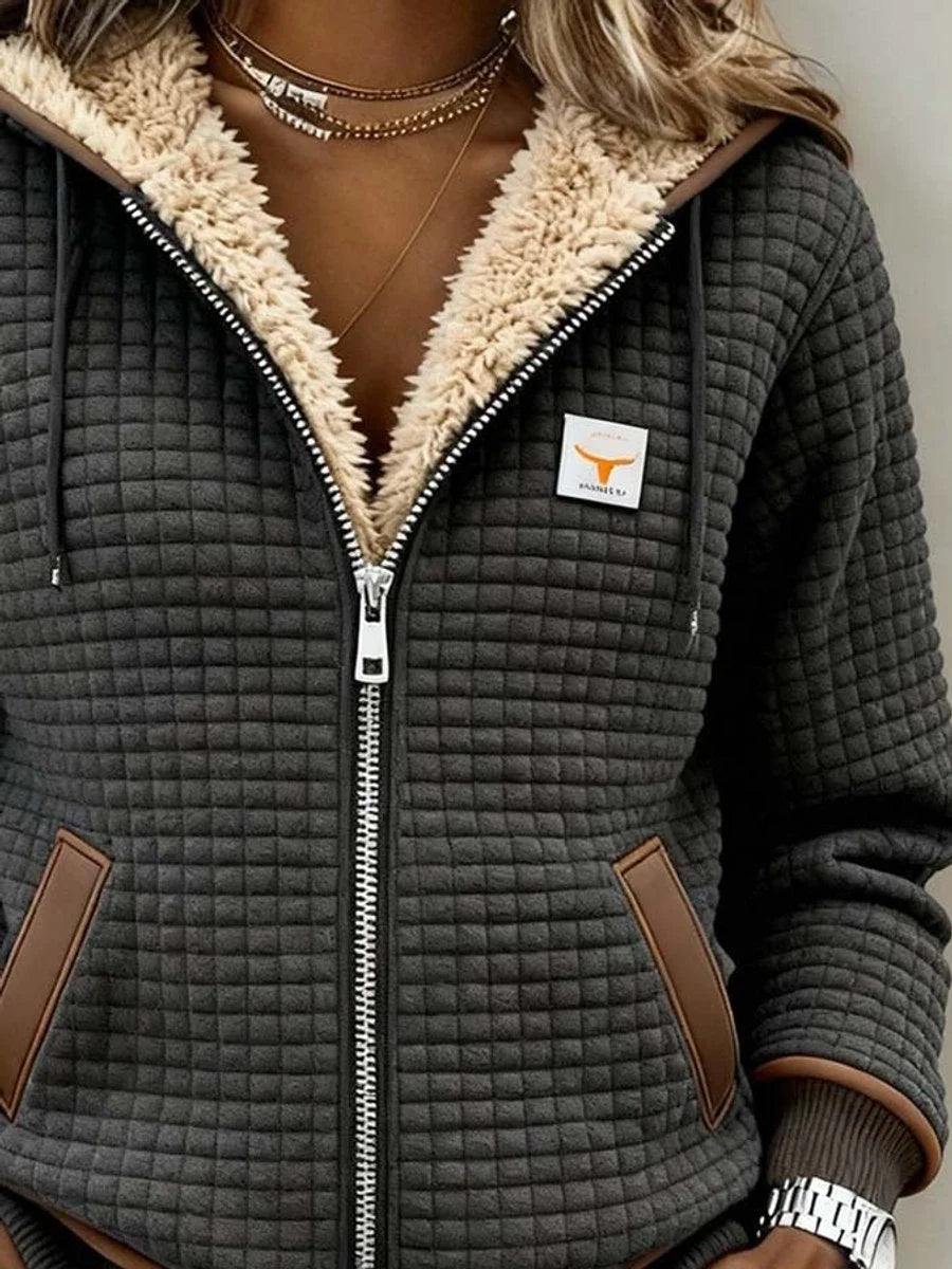 Zbliżenie kaptura z podszewką sherpa, zamka i naszywki z logo